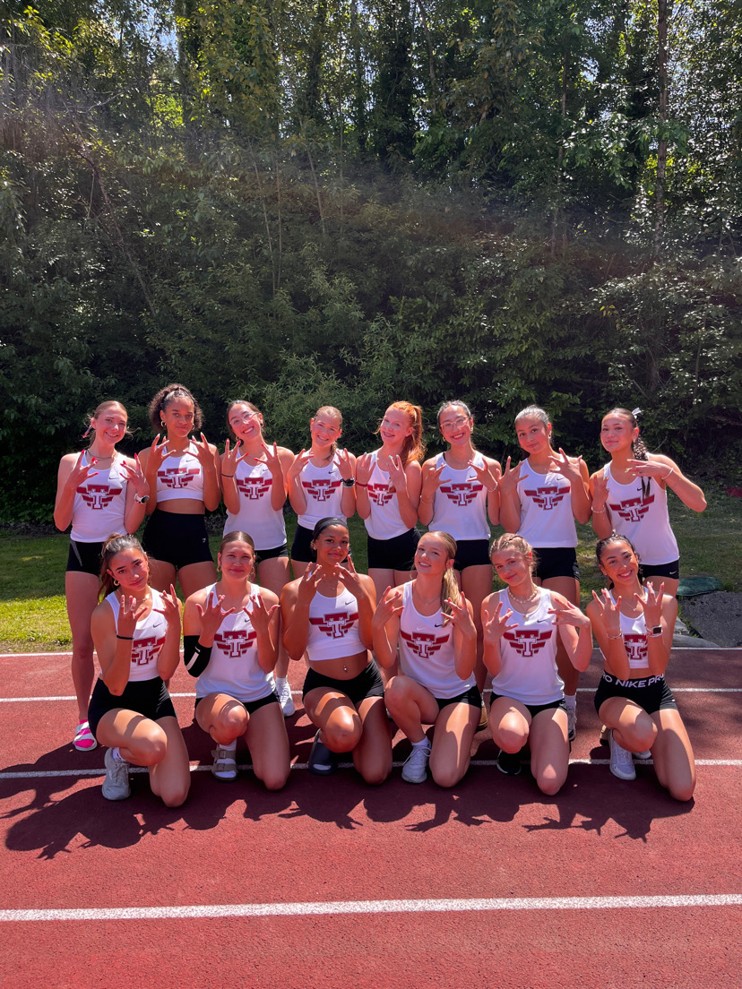 The Tualatin Girls’ track team poses together at a meet during the 2025 season.